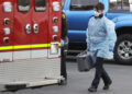 A Kirkland Fire and Rescue ambulance worker walks near a second ambulance after a patient was loaded into another vehicle for transport, Tuesday, March 10, 2020, at the Life Care Center in Kirkland, Wash., near Seattle. The nursing home is at the center of the outbreak of the new coronavirus in Washington state. (AP Photo/Ted S. Warren)